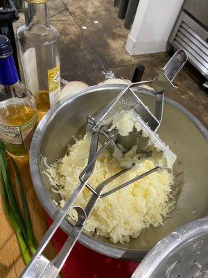 Putting potato in ricer