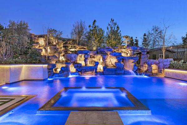 Artificial rock waterfall with hidden waterslide, zero edge pool and spa