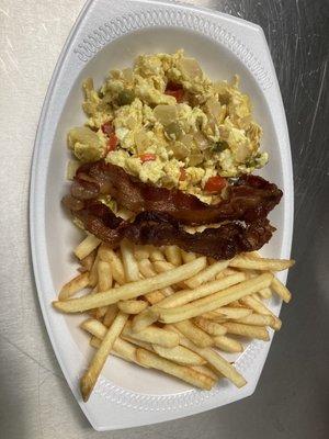 Revuelto con vegetales y tocino al lado y papas fritas  Scrambled eggs with veggies bacon on the side and house potatoes