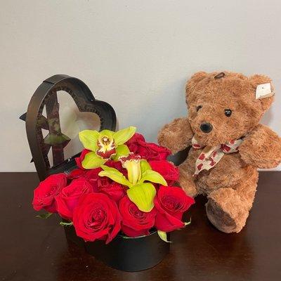 18 Red Roses nestled into a heart shaped hatbox complimented with two cymbidium blooms and a medium teddy bear.  All for $58 plus delivery.