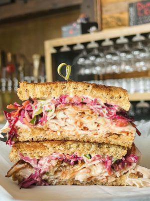 Rachel Sammie with a generous heap of Pepper Mill turkey, Swiss cheese, red cabbage slaw and house-made 1000 Island Dressing on rye bread.