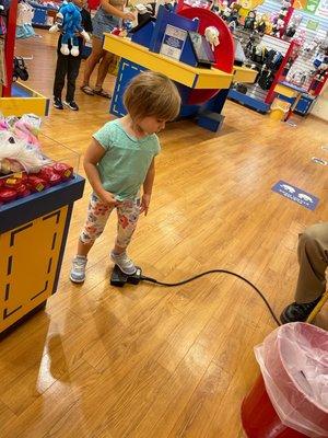 Stepping on the pedal to stuff her animal