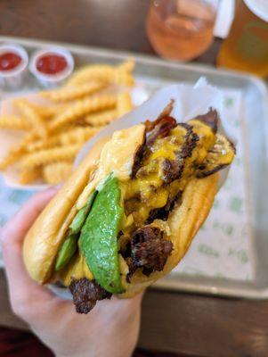 Close-up of Avocado Bacon Burger Double. $12.29. Angus beef cheeseburger, avocado, applewood-smoked bacon, ShackSauce, toasted potato bun.