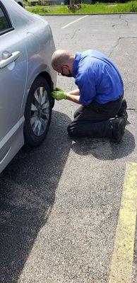 Chris at the Conrad's in Strongsville, screwing a nail into the fender lining, that's the plastic guard behind my tire.