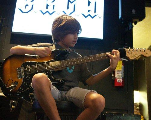 The guitar academy's youngest student performs.