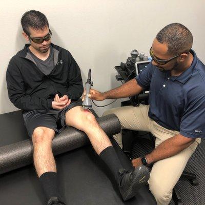 Dr. Bailey using the therapy laser to reduce joint inflammation in this patient's knee