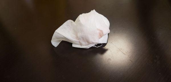 Bloody tissues sitting on the table in the waiting area of the ER.