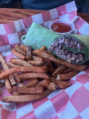 Steak and cheese on a spinach wrap with spicy fries