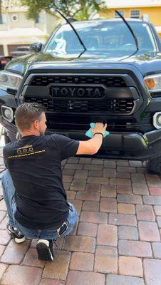 Owner and detailer, Eric, detailing Toyota Tacoma as part of MAD Diamond package with engine bay detailing add-on