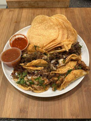 Carnitas and Al Pastor Tacos with whole tortilla chips and medium and spicy salsas