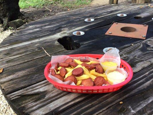 Salchipapa (French fries and hotdogs) with huancaina sauce