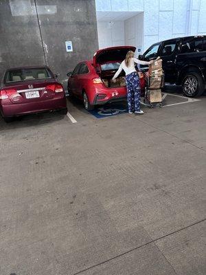 Amazon employee using a handicap space to collect groceries for delivery.