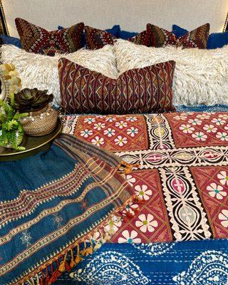 Colorful bedroom with an applique quilt and kilim and tulu pillows.