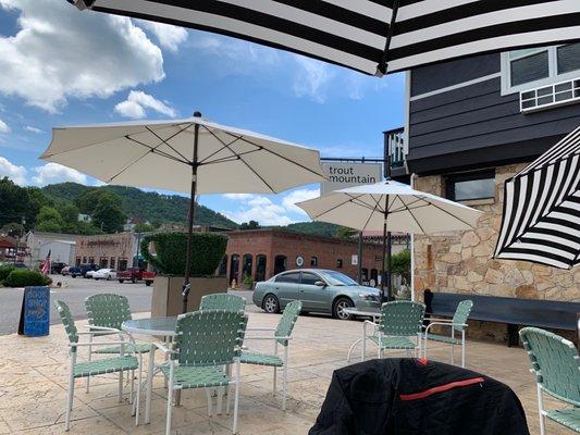 Outdoor seating with shade umbrellas and smiling waitstaff.