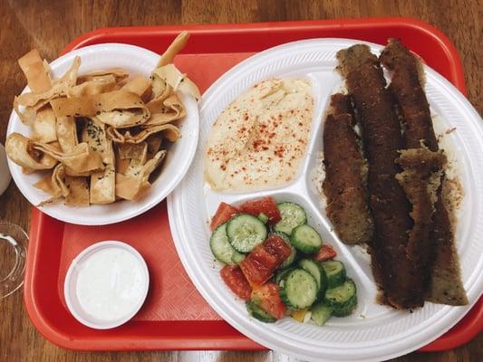 Gyro plate over rice with hummus, pita chips, and Lebanese salad