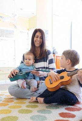 A family enjoying playing the ukulele.