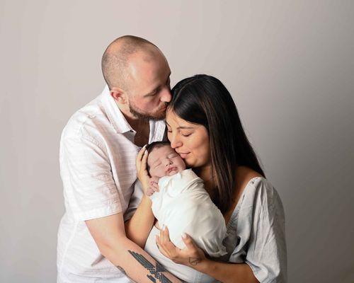 Mom and dad holding newborn swadled son at Hickory , NC Newborn Studio