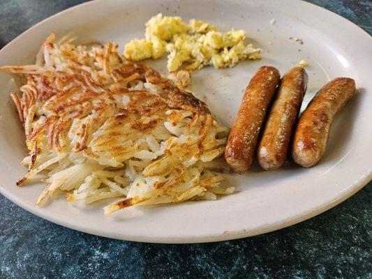 Hash browns, sausage links and scrambled eggs with toast.