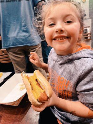 My daughter eating a hot dog