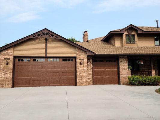 Carriage style garage doors in medium oak with windows.