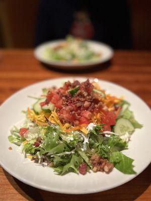 Side house salad with ranch. Greens, cucumber, tomato, carrots, cheese, bacon: