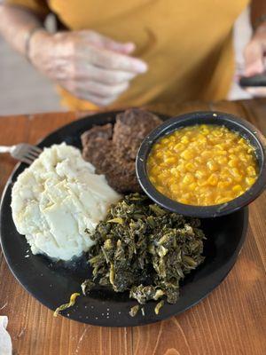 Hamburger Steak, creamed corn, mashed potatoes and collard greens.