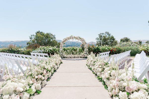 Floral arch and aisle flowers