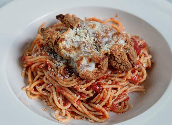 A generous breaded chicken cutlet layered with marinara and mozzarella, served over penne pasta with fries or salad