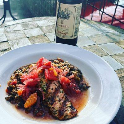 Grilled Steelhead with wilted kale and red lentils, topped with a citrus salsa.