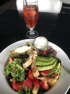 Delicious chicken, avocado, strawberry and roasted sweet pecan salad and ice tea.