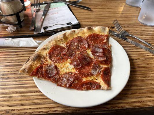 Slice of pepperoni pizza with bacon