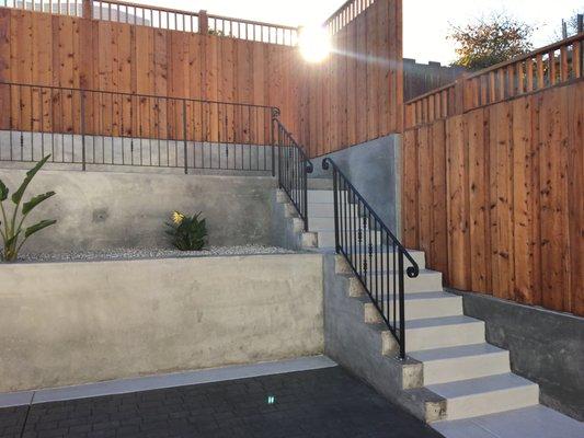 CONCRETE STAIRS AND PATIO, RETAINING WALL WITH PRESSURE TREATED WOOD FENCE & IRON RAILING