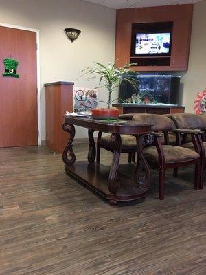 Clean and beautiful waiting room. Comfy chairs with armrests, tv on, fish tank calm and serene.