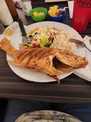 Whole fried red snapper, seasoned rice, salad.