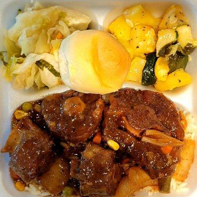 Oxtails, cabbage, coco bread and mixed vegetables.