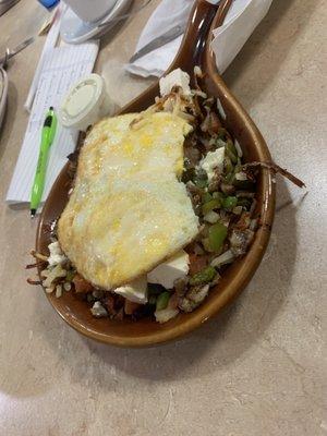 Grecian skillet ( with a couple of bites missing!). Two eggs over hard, hashbrowns, gyro meat, onions,gr peppers, tomatoes,feta cheese.