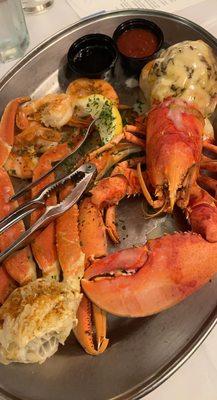 Steamed Whole Maine Lobster stuffed with crab cake and sides of shrimp and fries