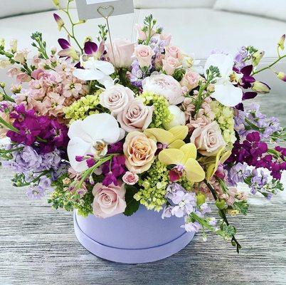 Large arrangement of mixed blooms in a velvet hat box