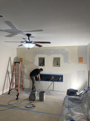 Drywall work after wall build and fireplace installation.