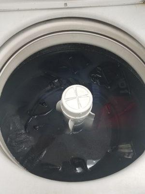 Wet clothes sitting inside broken washer