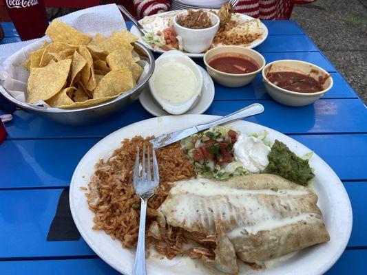 Chicken chimichanga, rice, queso. Other plate is quesadilla fajita and refried beans.