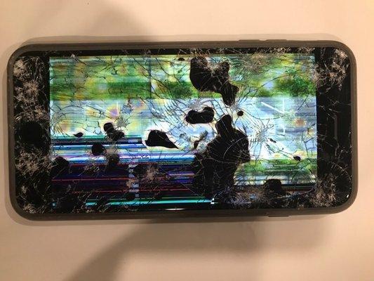 Shattered phone with screen on