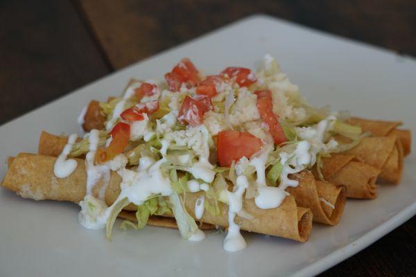 Five Rolled Tacos Shredded Chicken or Shredded Beef, topped with cheese, lettuce, sour cream and tomato.