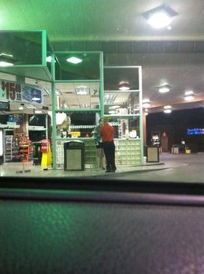 Gas station employee smoking a cigarette w/girlfriend 30 ft from pumps!