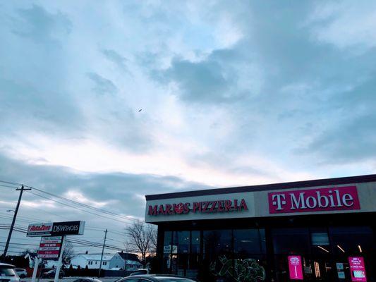 Entrance sign on left and store sign above a blue sky on a clear cold day