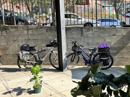 Protected patio has seating and place for bikes