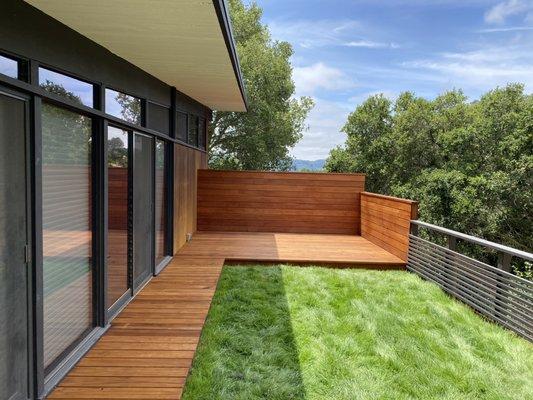 Heart-B redwood deck and privacy wall with black horizontal slat railing