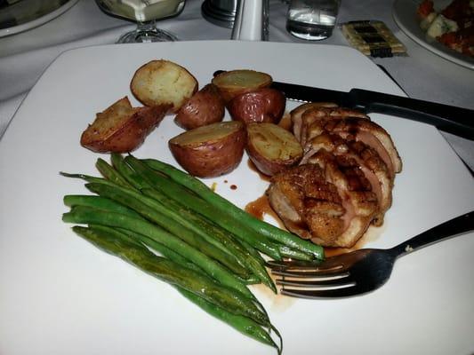 Seared duck breast with a currant demi glaze, garlic string beans and herb roasted red potatoes.