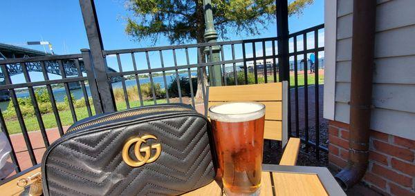 Patio seating with a view of the York River and Coleman Bridge with a cold one