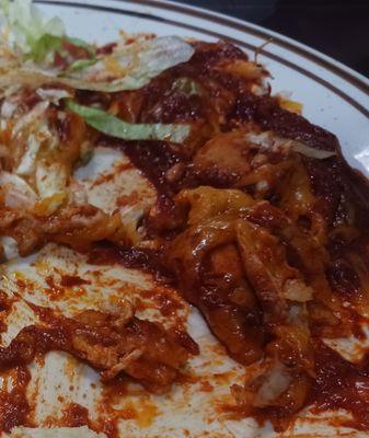 Chicken Enchilladas....folded tortillas lot of sauce and chicken on top of the enchilada